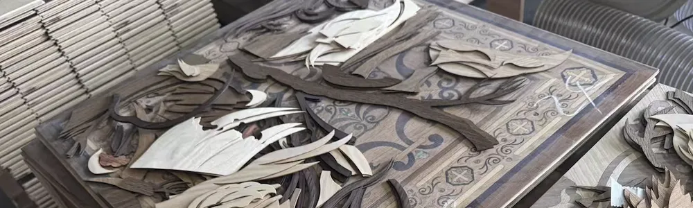 Assortment of curved wooden veneer pieces spread on a carved decorative table in a woodworking workshop.